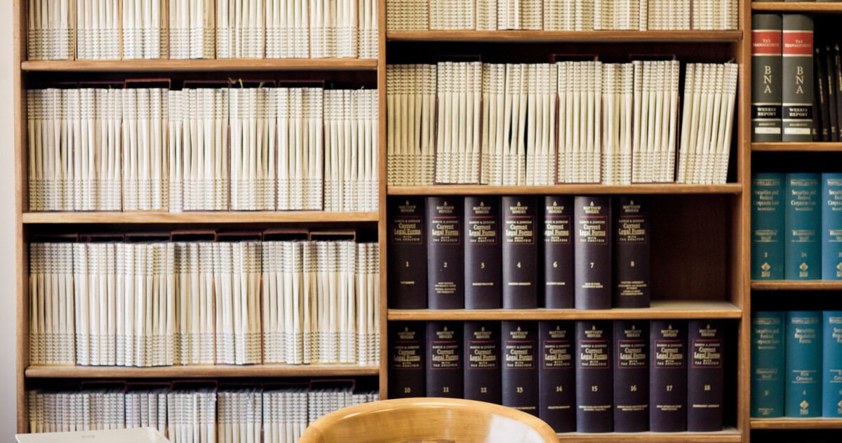 table in front of bookshelf containing legal and regulation reference books